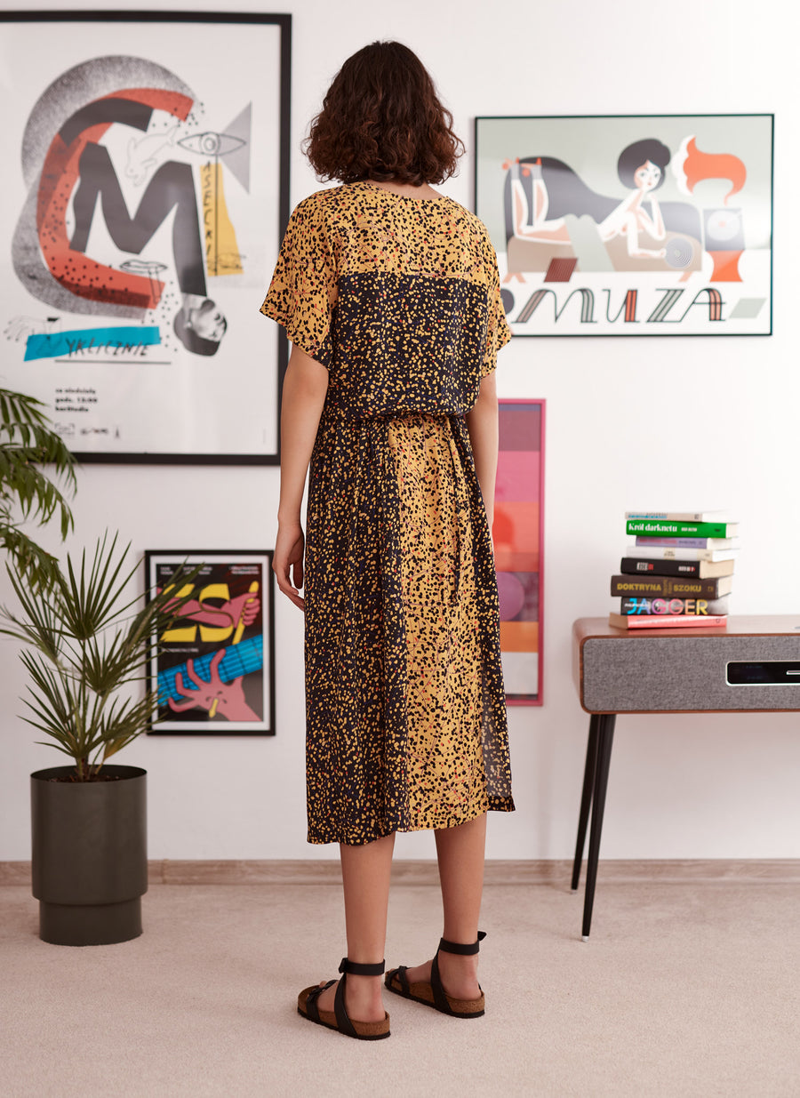 Black and yellow splatter kimono sleeve top worn by a model. Styled with matching slip dress. Back