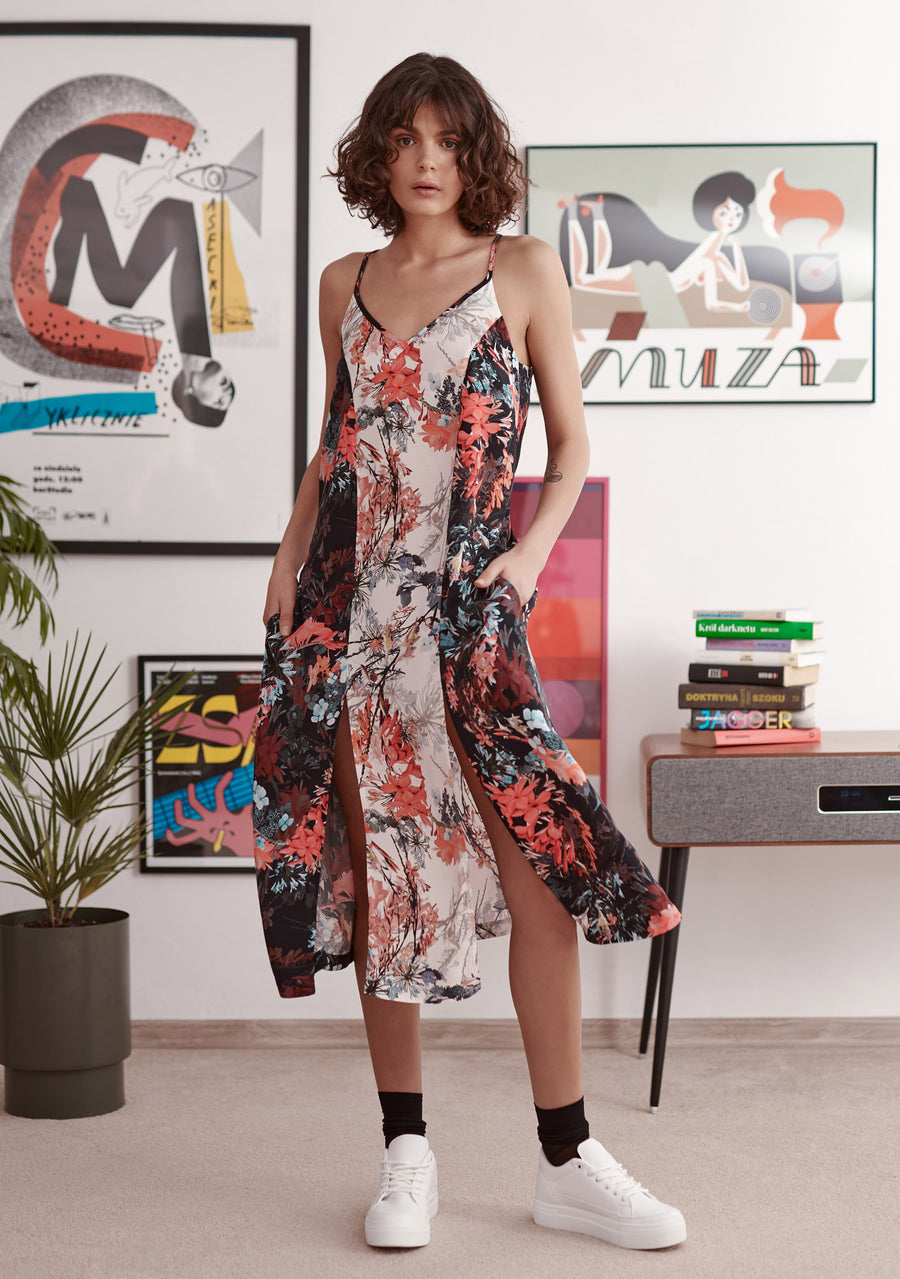 Red and blue floral print slip dress with contrast panels and splits at hem. Worn by model. Styled with black socks and white trainers