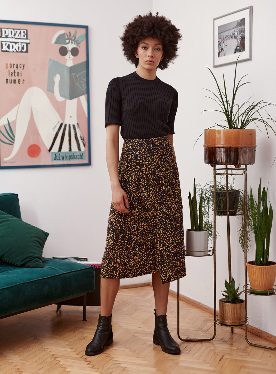 Black and yellow splatter print wrap skirt worn by a model. Styled with black top and chelsea boots.